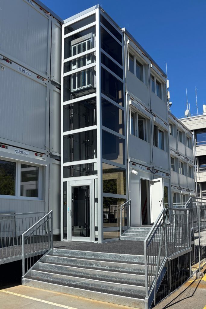 Home lift Eltec Lift HLB elettrico con struttura TA, vetro fumé e porte a soffietto inox in cabina; soluzione su misura che unisce accessibilità, comfort e design integrato. Vista lato accesso.